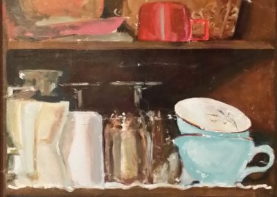 Cabinet shelve showing cups, glasses, and ceramic bowls.